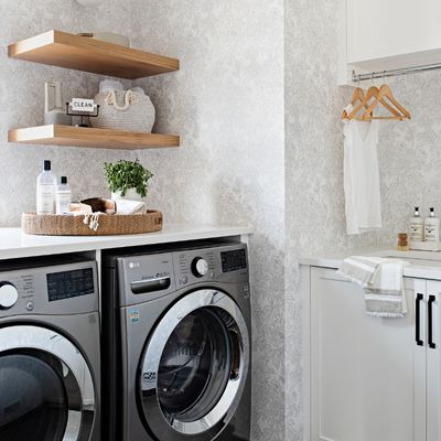 open wood shelving in designer laundry room with floral wallpaper